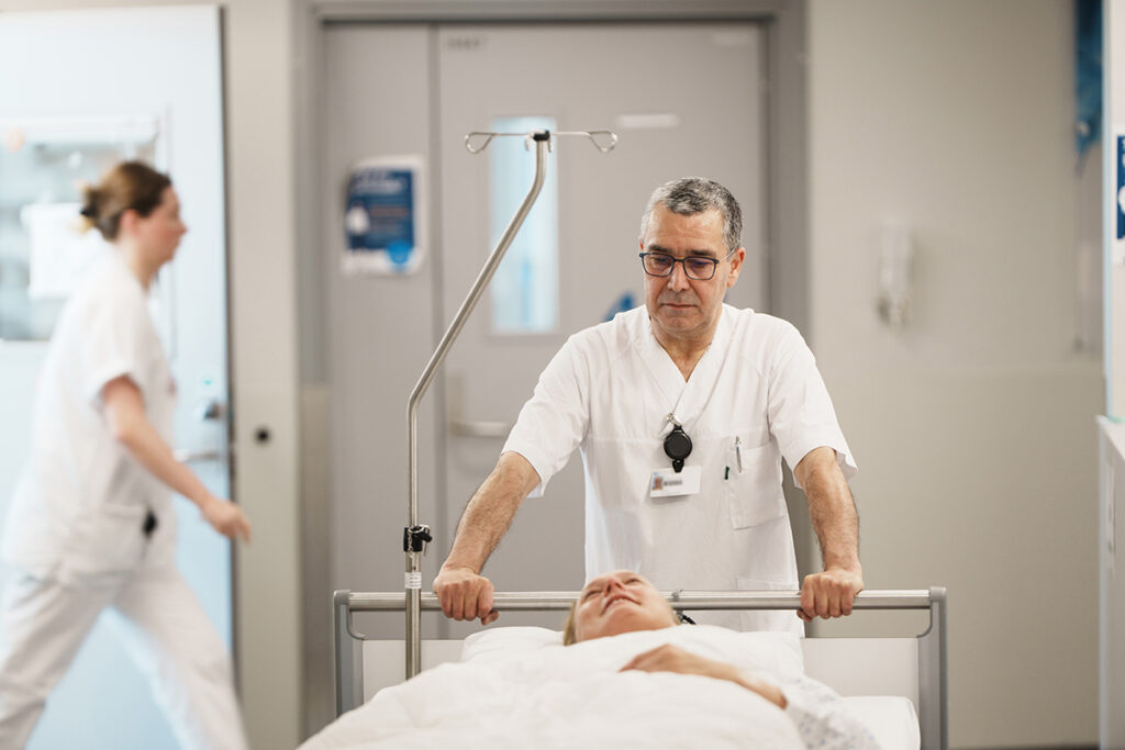 Porter transporting a patient through a hospital corridor.