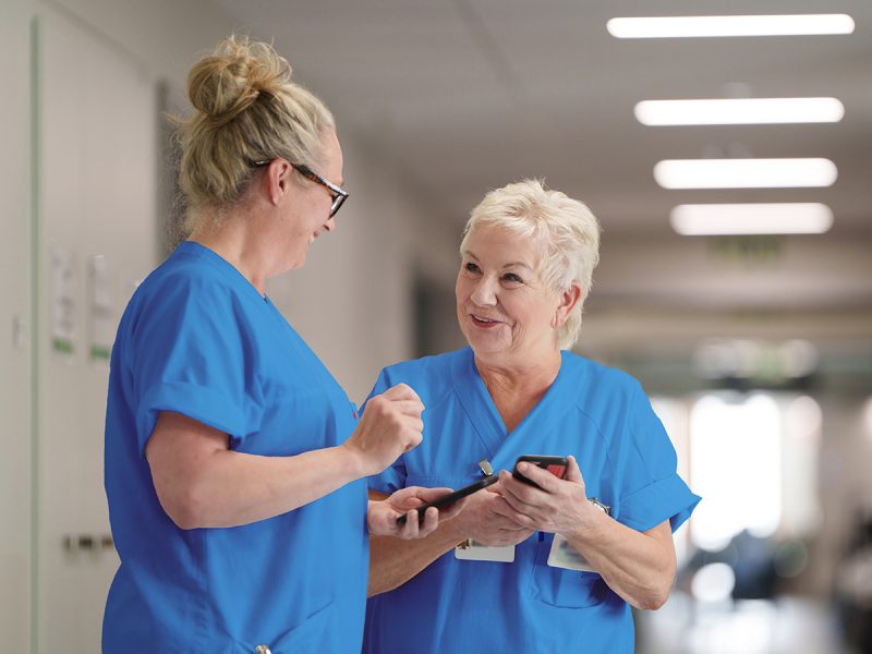 Two nurses with nurse call on their mobile phones