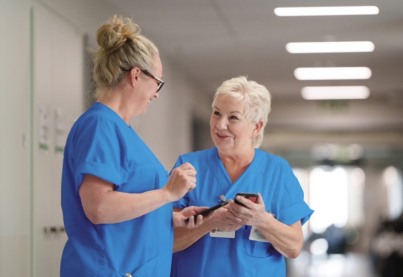 Two nurses with nurse call on their mobile phones