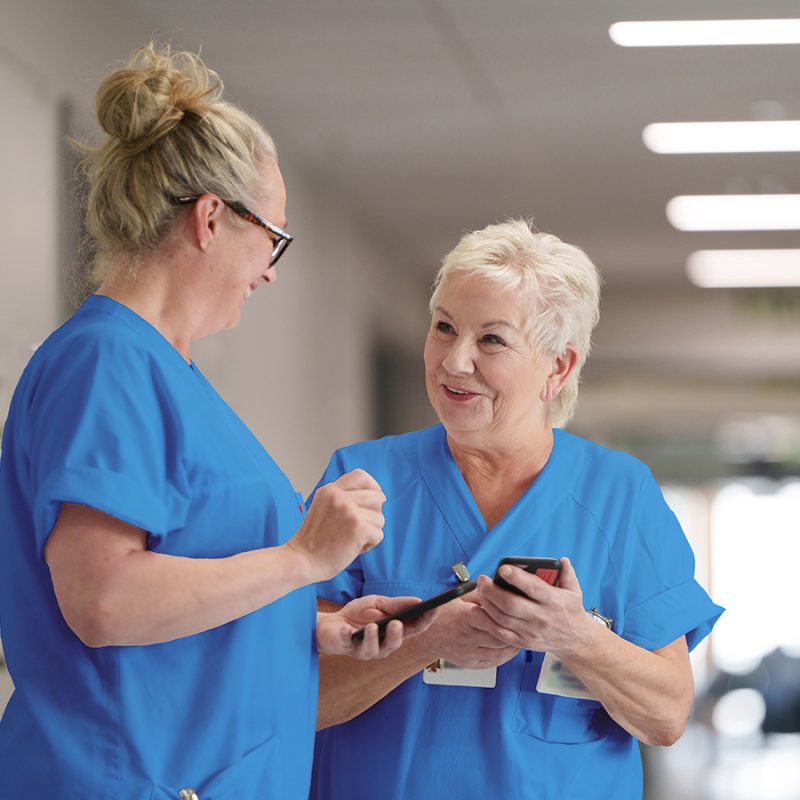Two nurses with nurse call on their mobile phones