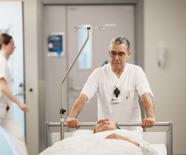 Porter transporting a patient through a hospital corridor.