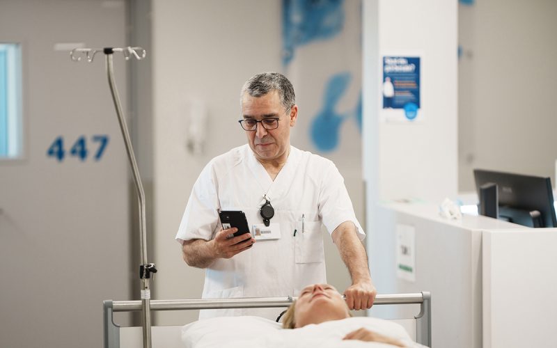 Hospital staff member moving a patient between departments as part of a coordinated patient transport workflow.