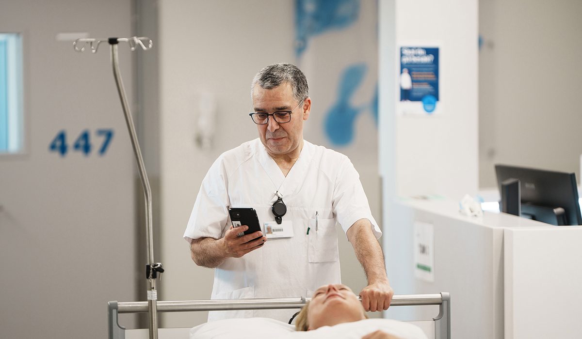 Hospital staff member moving a patient between departments as part of a coordinated patient transport workflow.