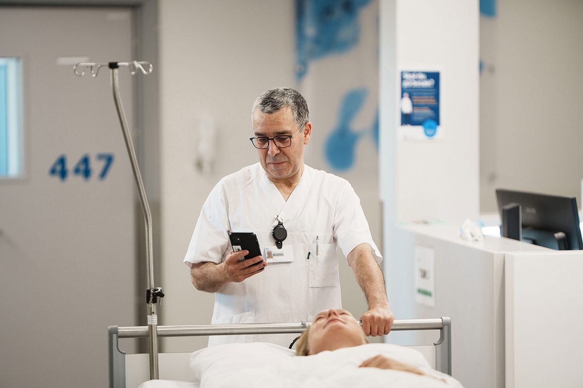 Hospital staff member moving a patient between departments as part of a coordinated patient transport workflow.