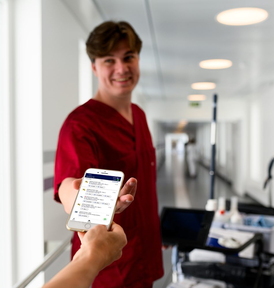 Member of hospital support staff receiving a task assignment on a mobile device using a real-time coordination system.